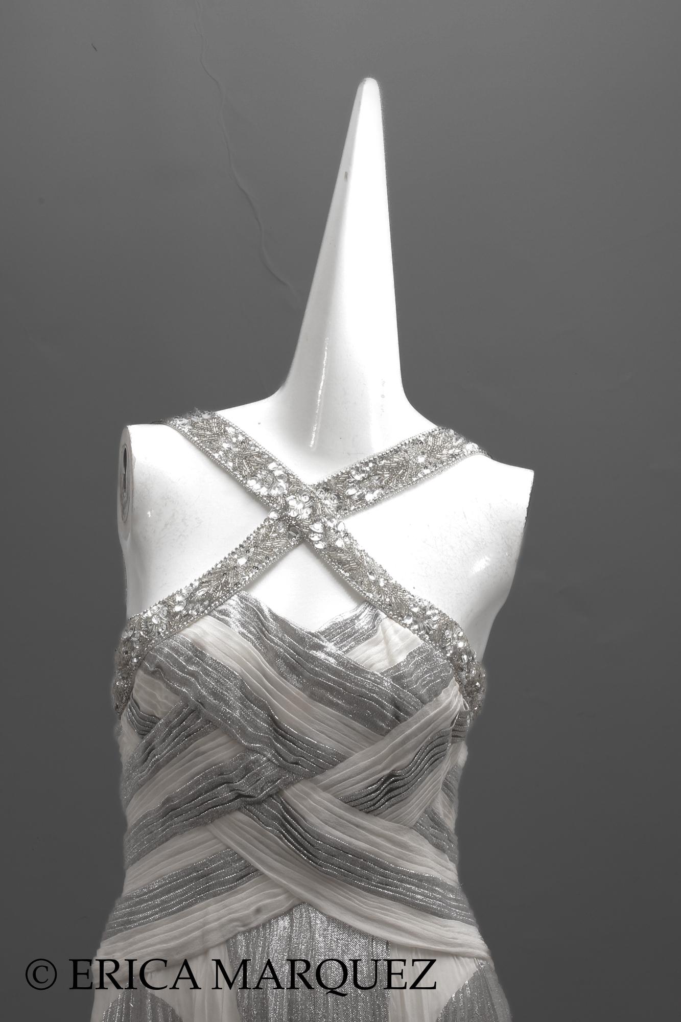 Zuhair Murad, Abito Chevron metallizzato argento con corpetto intrecciato e cinturino con strass.

Acquistato ad Abu Dhabi, questo elegante abito da sera è impreziosito da numerosi strass sulle fasce trasversali. Il corpetto è aderente e plissettato