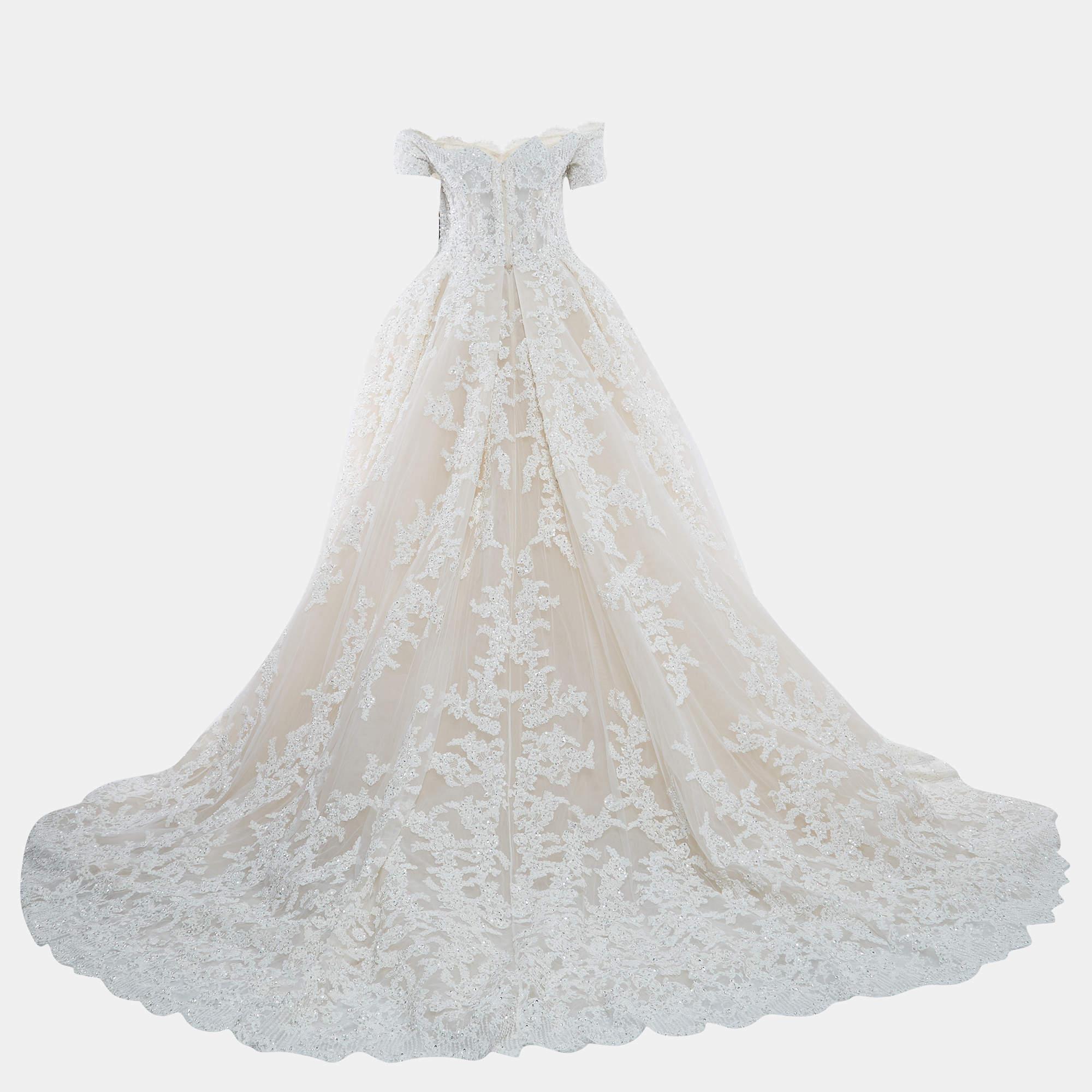 The Zuhair Murad wedding gown is a stunning and ethereal choice for brides. The gown features intricate embroidery on delicate ivory mesh, creating a romantic and timeless look. The design showcases Murad's signature craftsmanship, with a fitted