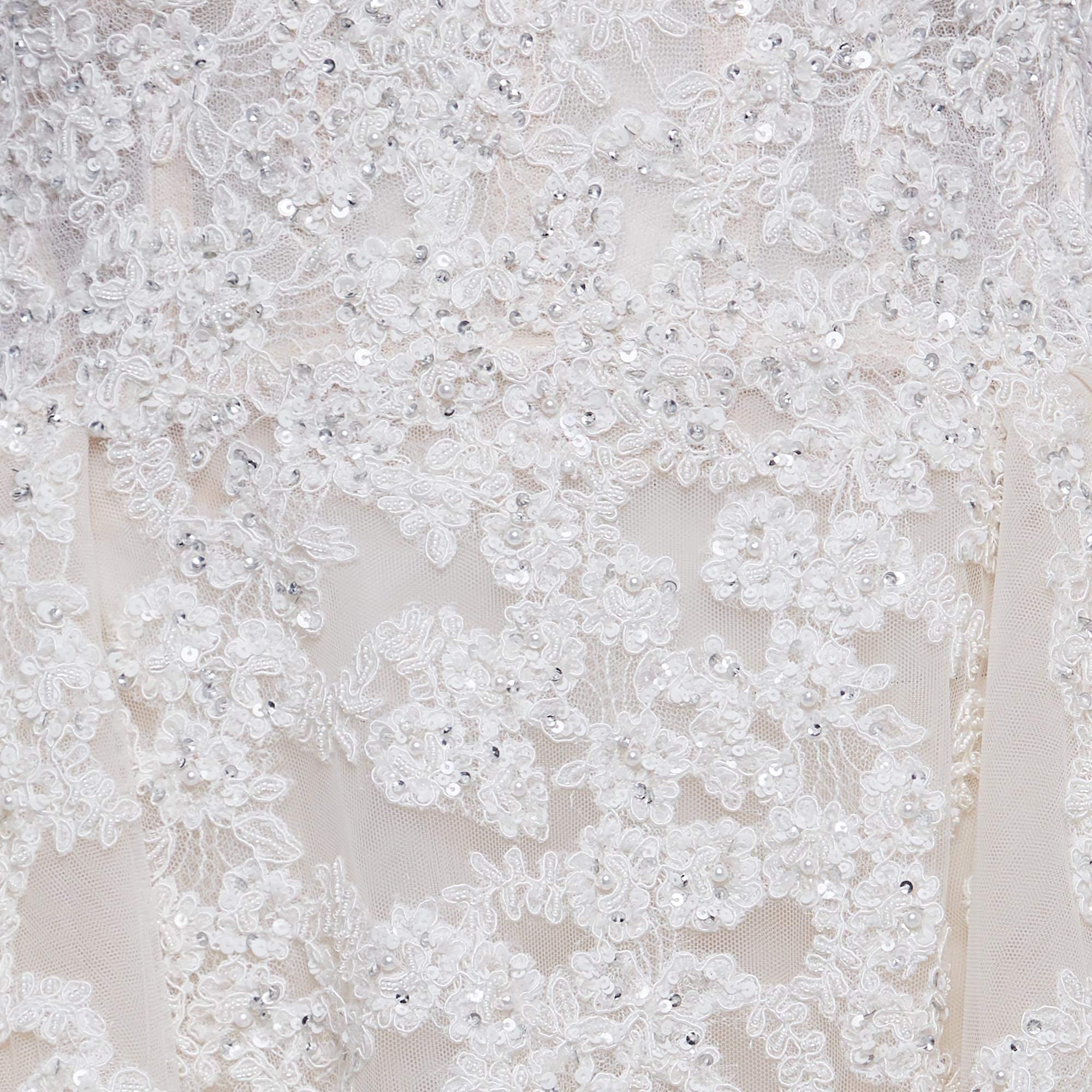 El vestido de novia Zuhair Murad es una elección impresionante y etérea para las novias. El vestido presenta un intrincado bordado sobre una delicada malla marfil, creando un aspecto romántico y atemporal. El diseño muestra la artesanía