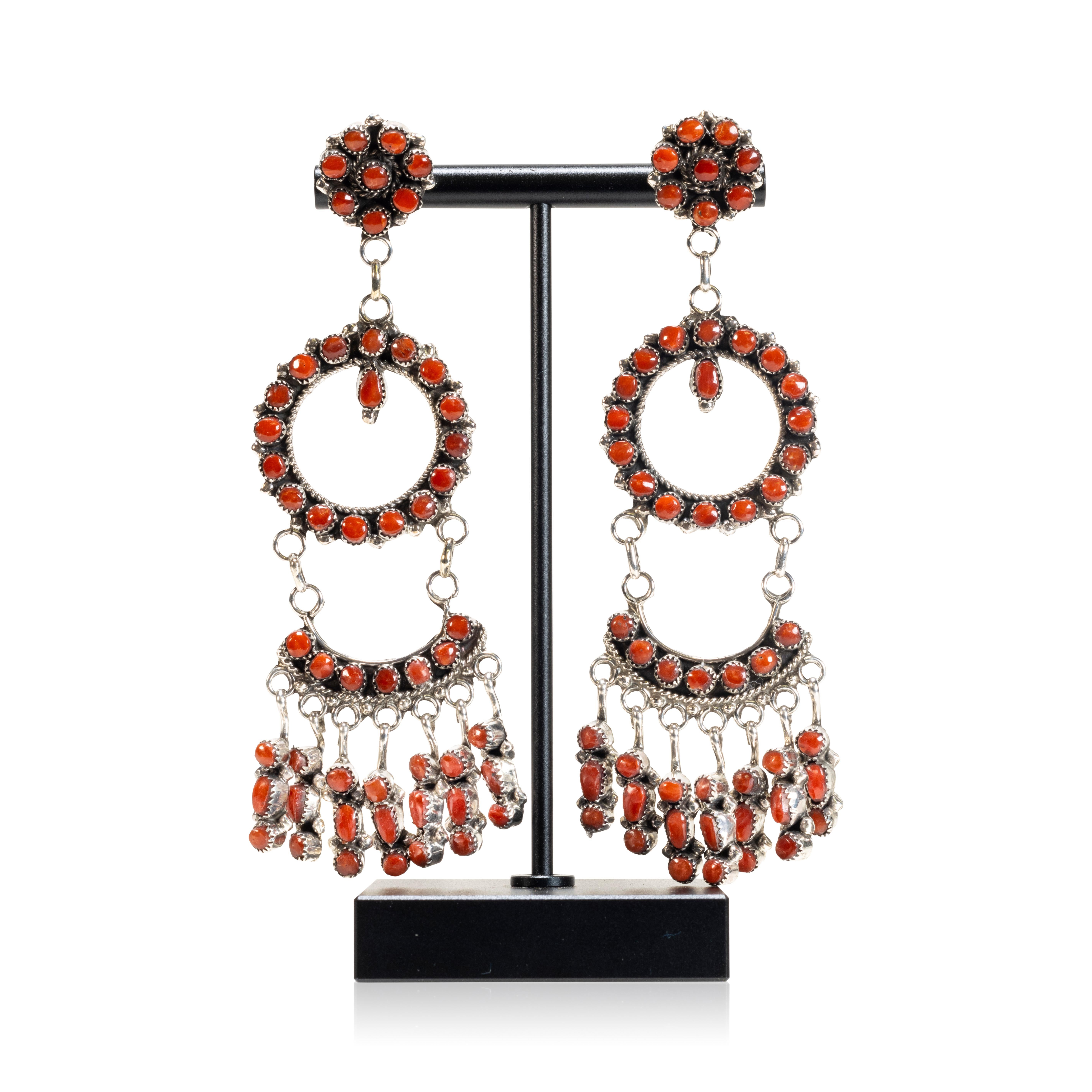 Zuni made natural oxblood coral and sterling silver chandelier earrings by artist Phyllis Laate. Each earring has 53 small coral cabochons hanging in layers that move gracefully. Hallmarked on the back. Lightweight with sterling post backs.

PERIOD: