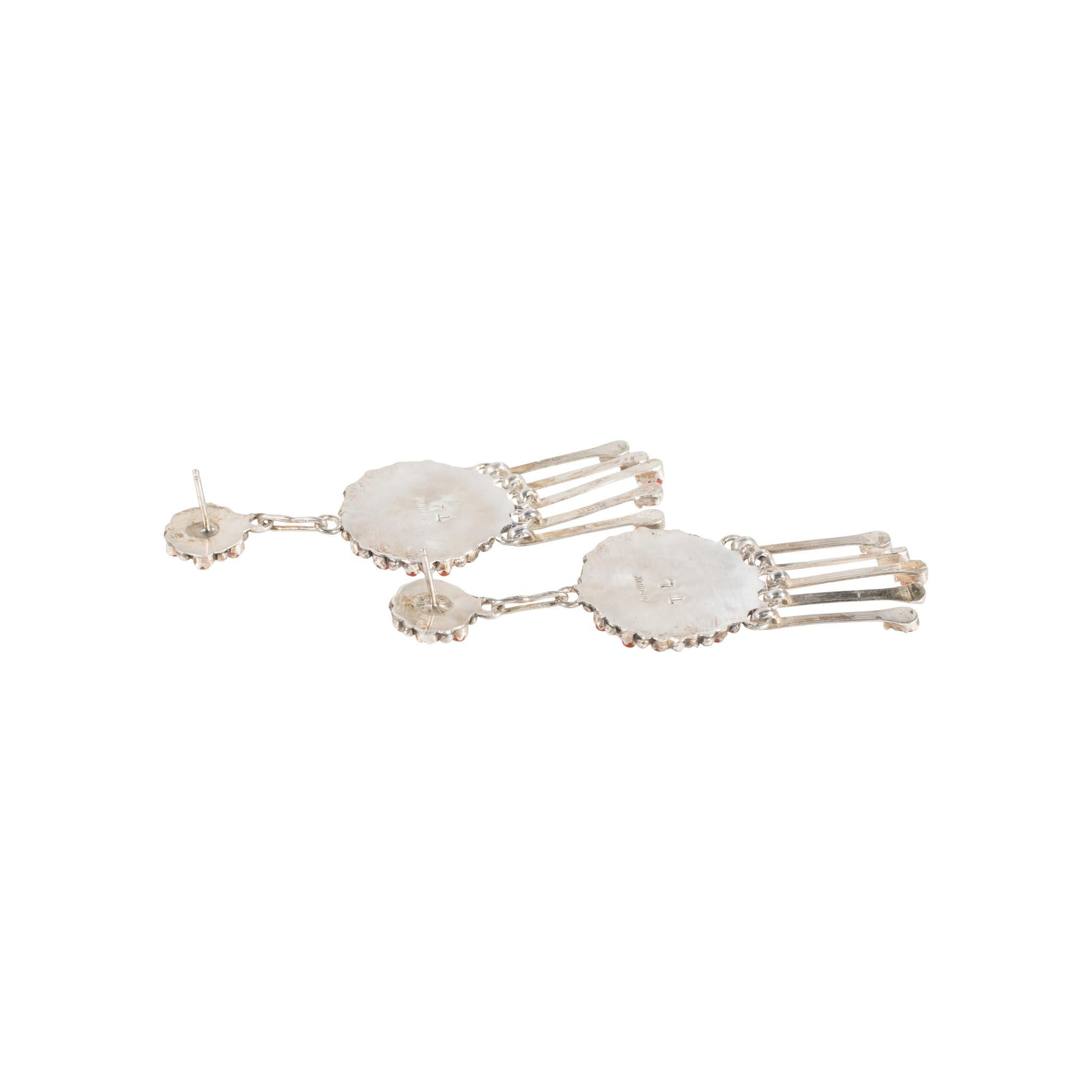 Orecchini pendenti a lampadario in corallo petit-point di Zuni e argento sterling con chiusura a perno. Design floreale a raggiera nella parte superiore con sei pietre di corallo a punta piccola e perline in argento. Design a raggiera specchiato