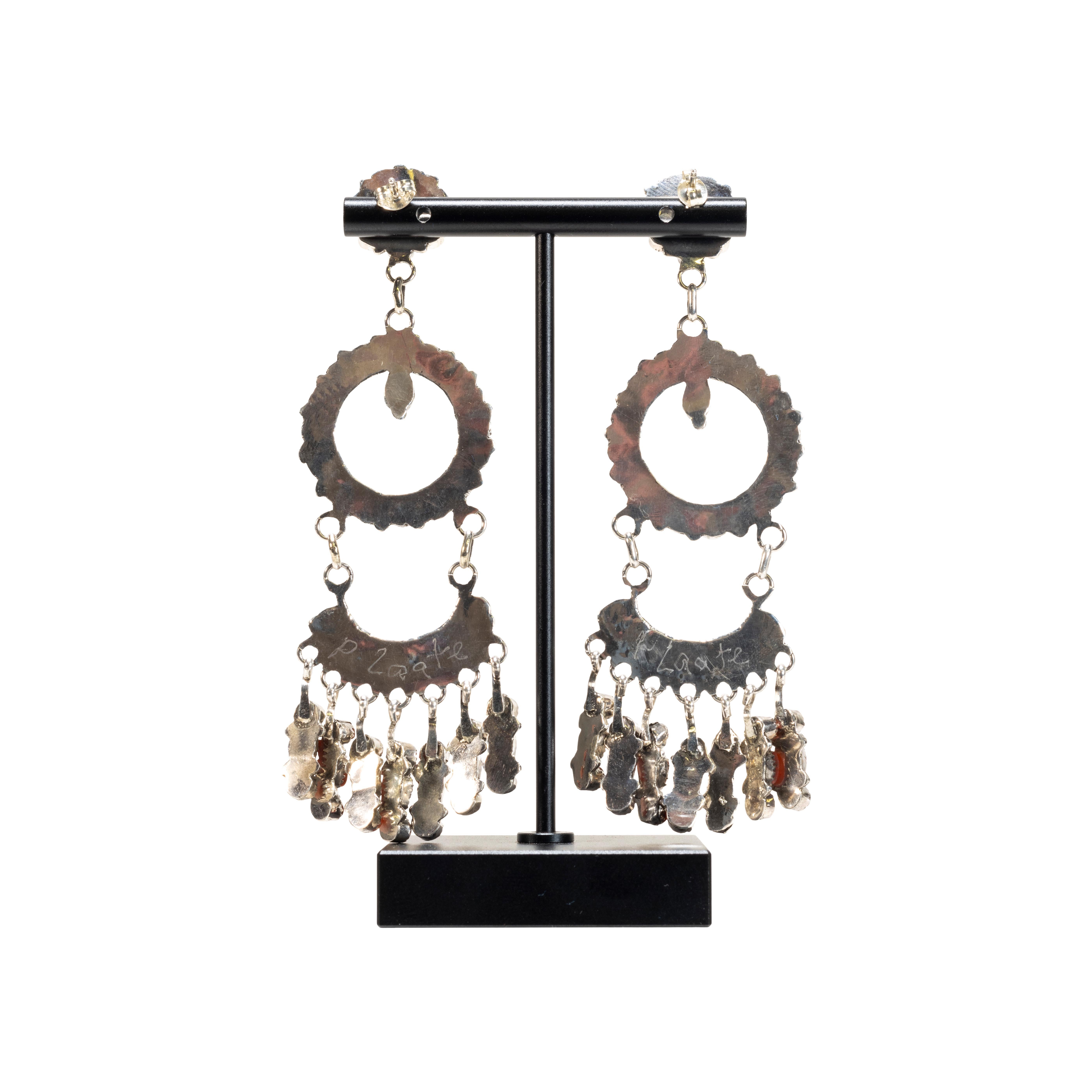 Zuni made natural oxblood coral and sterling silver chandelier earrings by artist Phyllis Laate. Each earring has 53 small coral cabochons hanging in layers that move gracefully. Hallmarked on the back. Post backs.

PERIOD: Contemporary
ORIGIN: