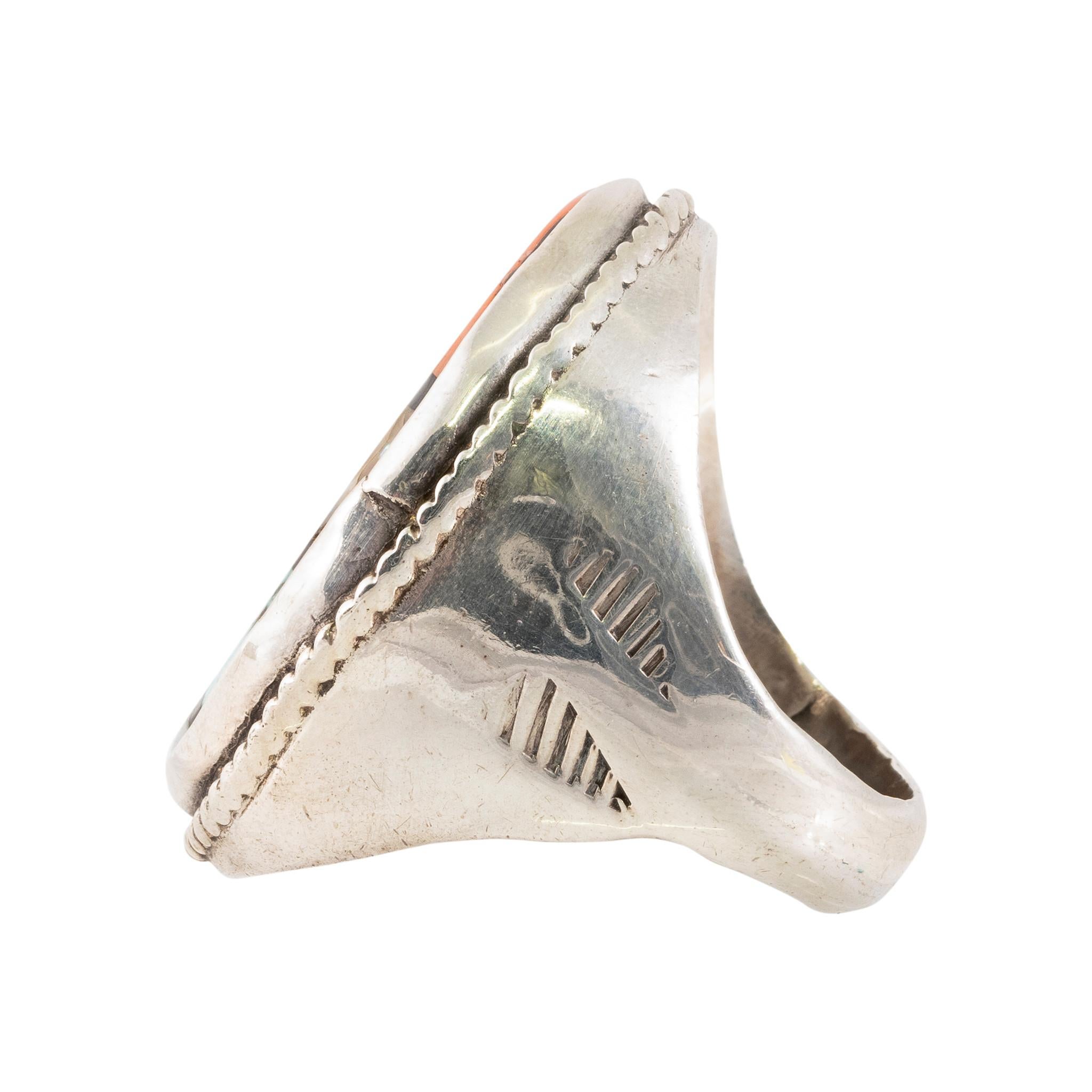 Zuni ring with onyx, turquoise, spiny oyster, abalone, and mother of pearl geometric design. Inlay design surrounded by twisted rope border, set in thick sterling silver band with hatched designs on sides. Sturdy piece, great for formal or everyday