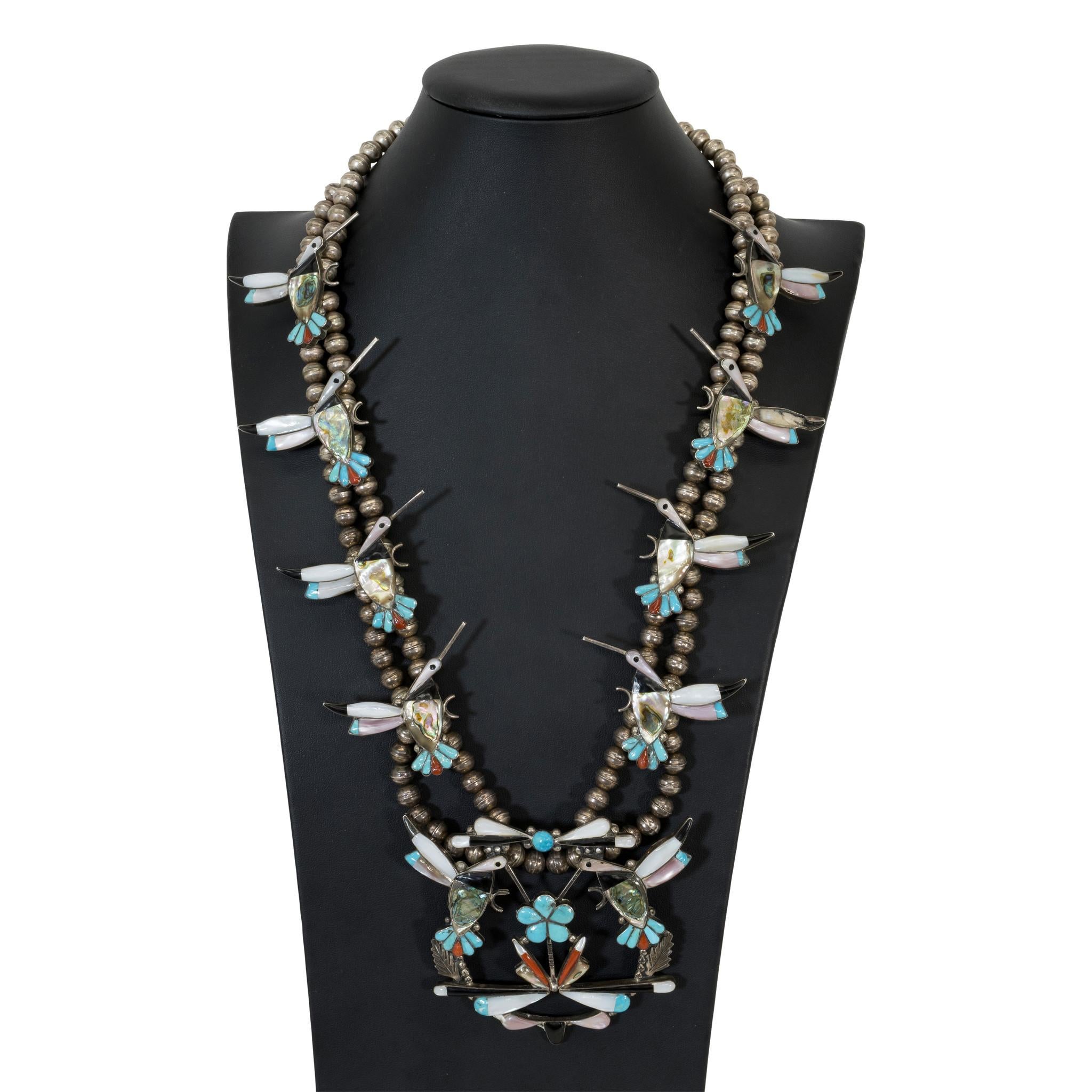 Collana di fiori di zucca in argento e pietre intarsiate dei nativi americani Zuni, composta da otto colibrì e naja abbinati su una doppia catena di perle Navajo in argento. Pietre di turchese della Bella Addormentata intarsiate, corallo, abalone,