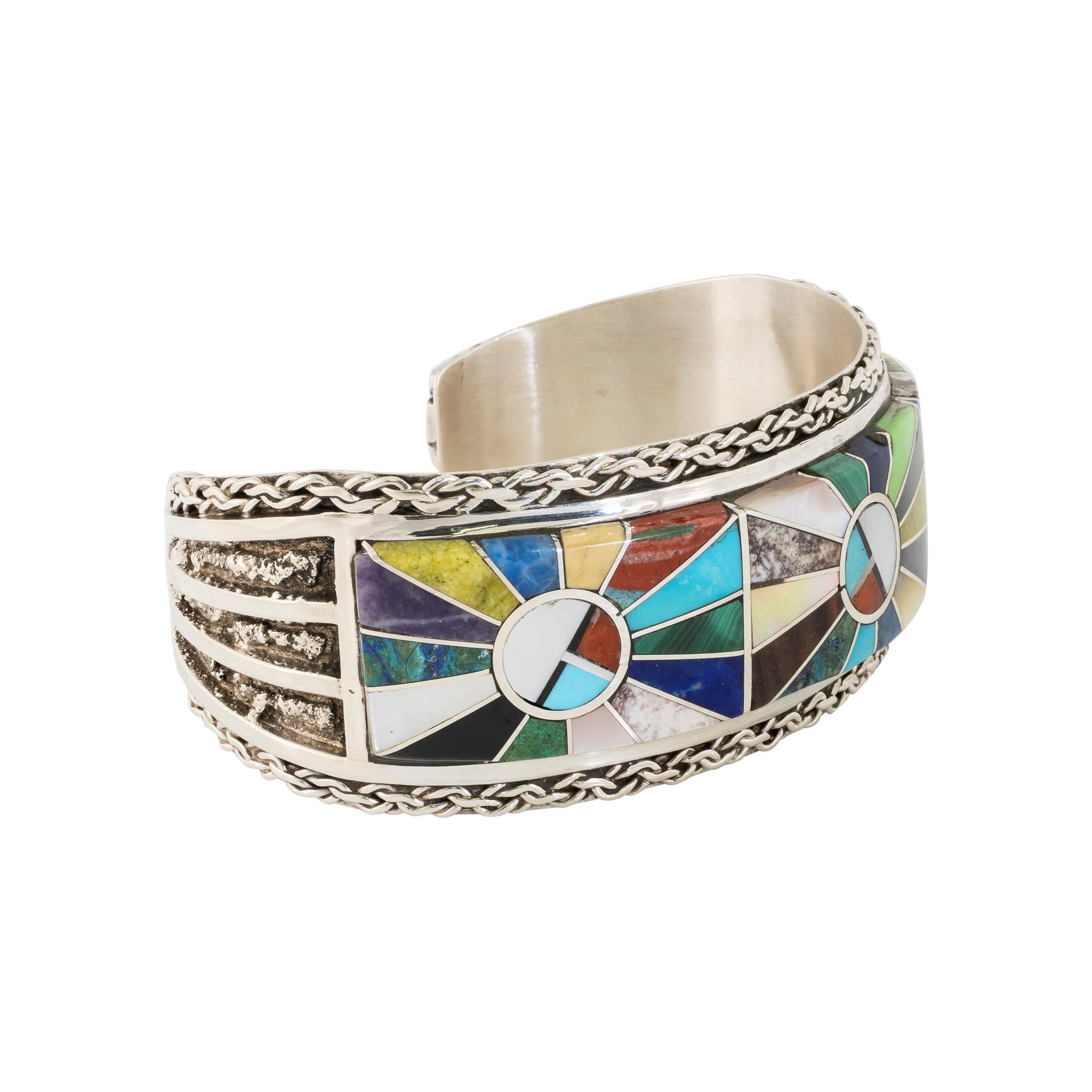 Beautiful Zuni bracelet of various geometric inlaid stones set in sterling silver with fine twisted chain link border. Sits flush against the skin. Stones consist of turquoise, abalone, mother of pearl, onyx, coral, malachite, lapis and white