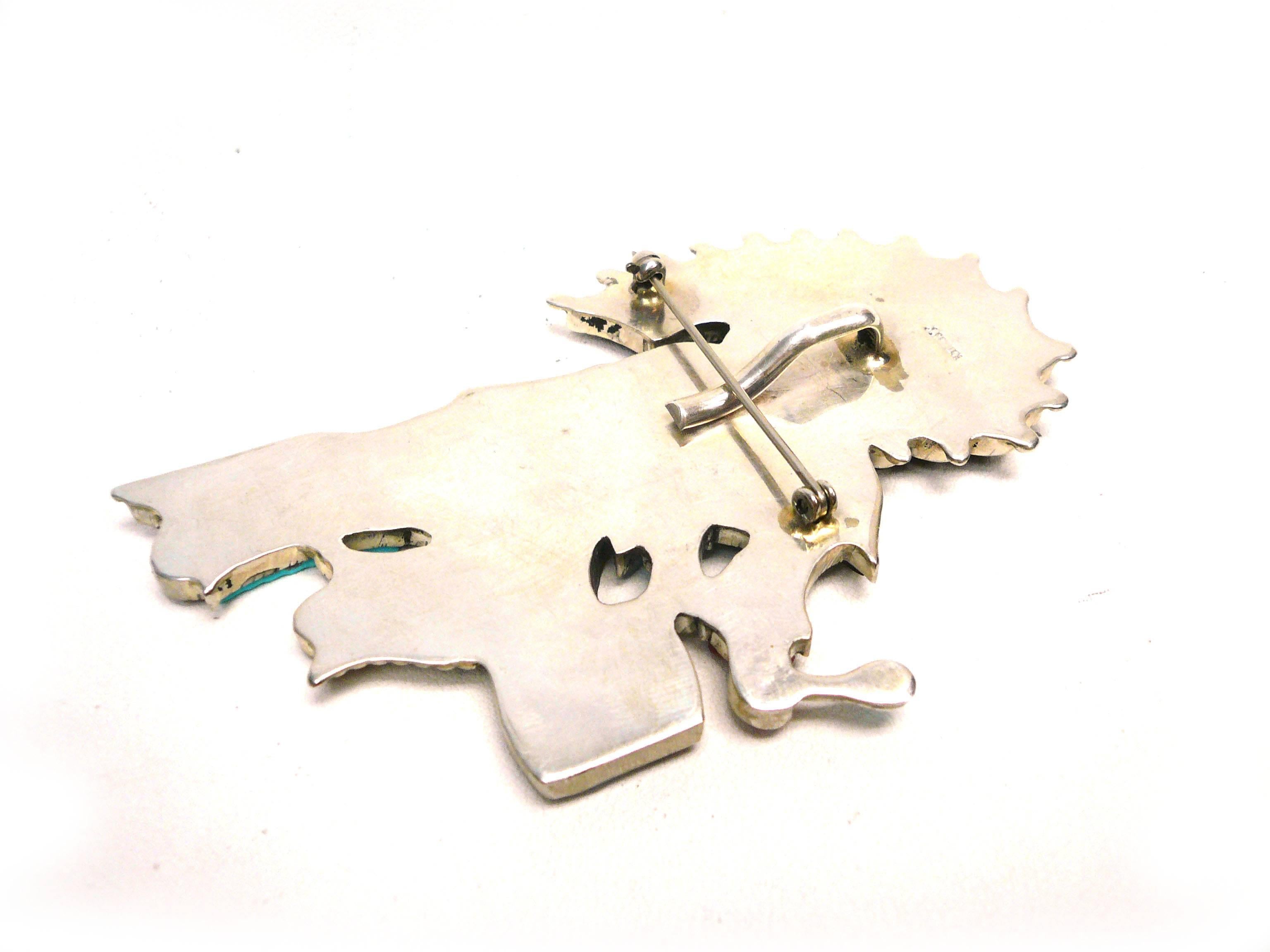 Made of sterling this charming drummer pendant/brooch features mother of pearl, turquoise, coral and abalone inlay. The Zuni are known for their impeccable inlay skills.
Artist J Beyuka's designs are inspired by his famous father Eddie