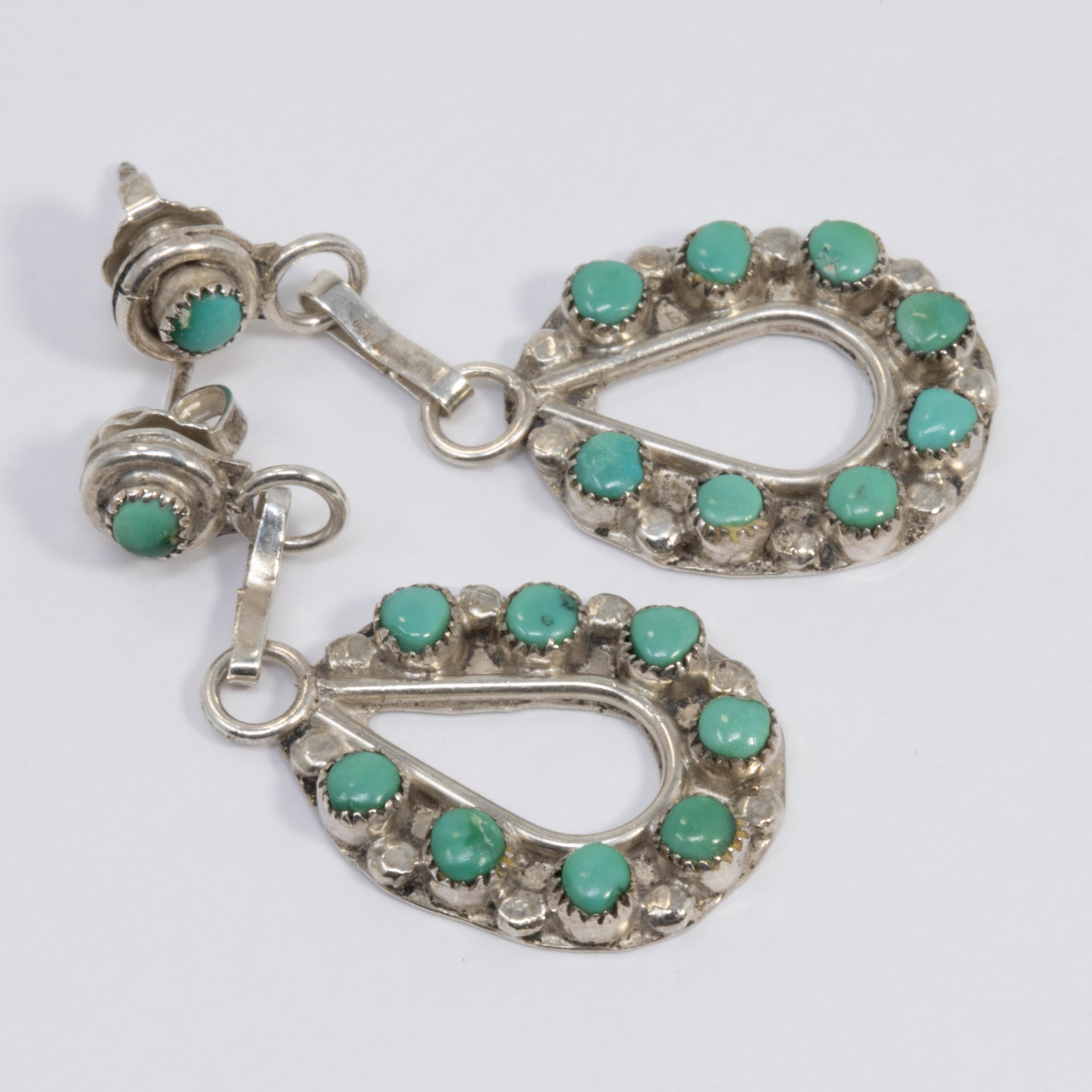  A pair of sterling silver earrings decorated with bezel-set, polished, turquoise beads. Danling style with post backs. Made by skilled Native American silversmiths, circa mid 1900s.

Hallmarks: Sterling