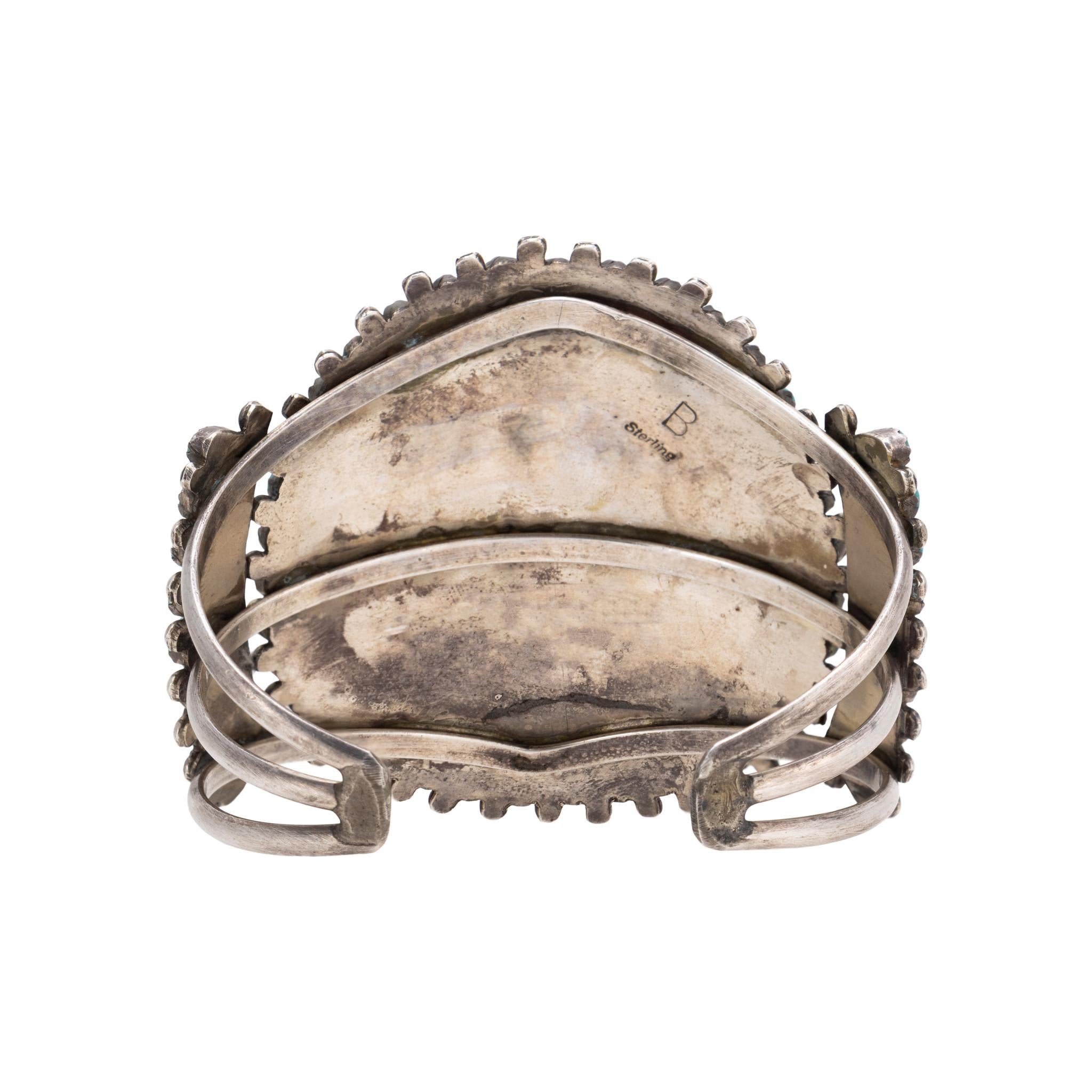Zuni needlepoint sterling and turquoise cuff bracelet by Lance & Cordelia Waatsa, Zuni. Features impressively cut needlepoint turquoise set in saw tooth sterling silver bezels accented with appliqued sterling robe and dots between and at the tip of