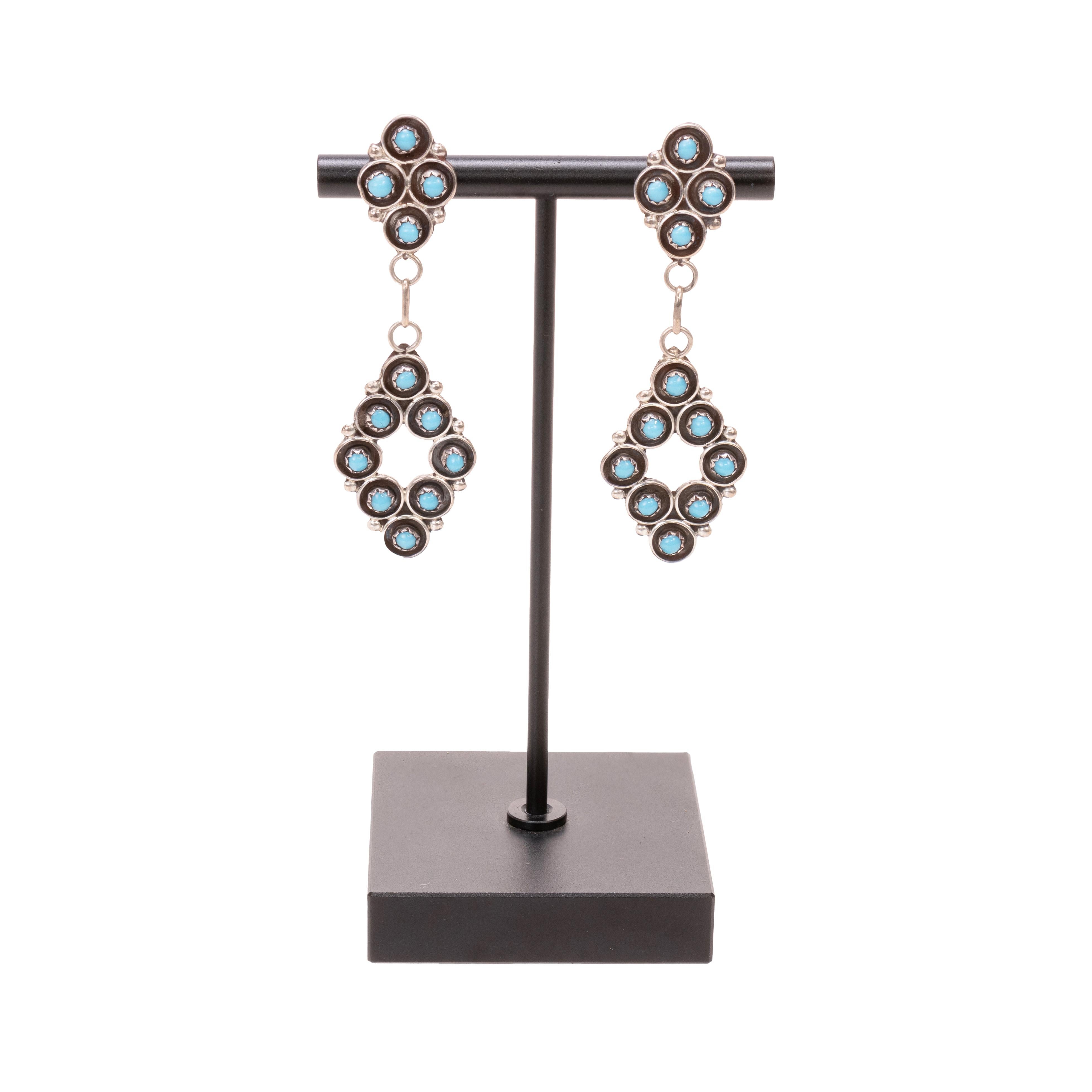 Orecchini a lampadario in turchese petit point di Zuni e argento sterling. Ogni orecchino ha dodici perle di turchese Sleeping Beauty con castone a dente di sega e incastonatura shadowbox e perline in argento. La parte superiore presenta un gruppo