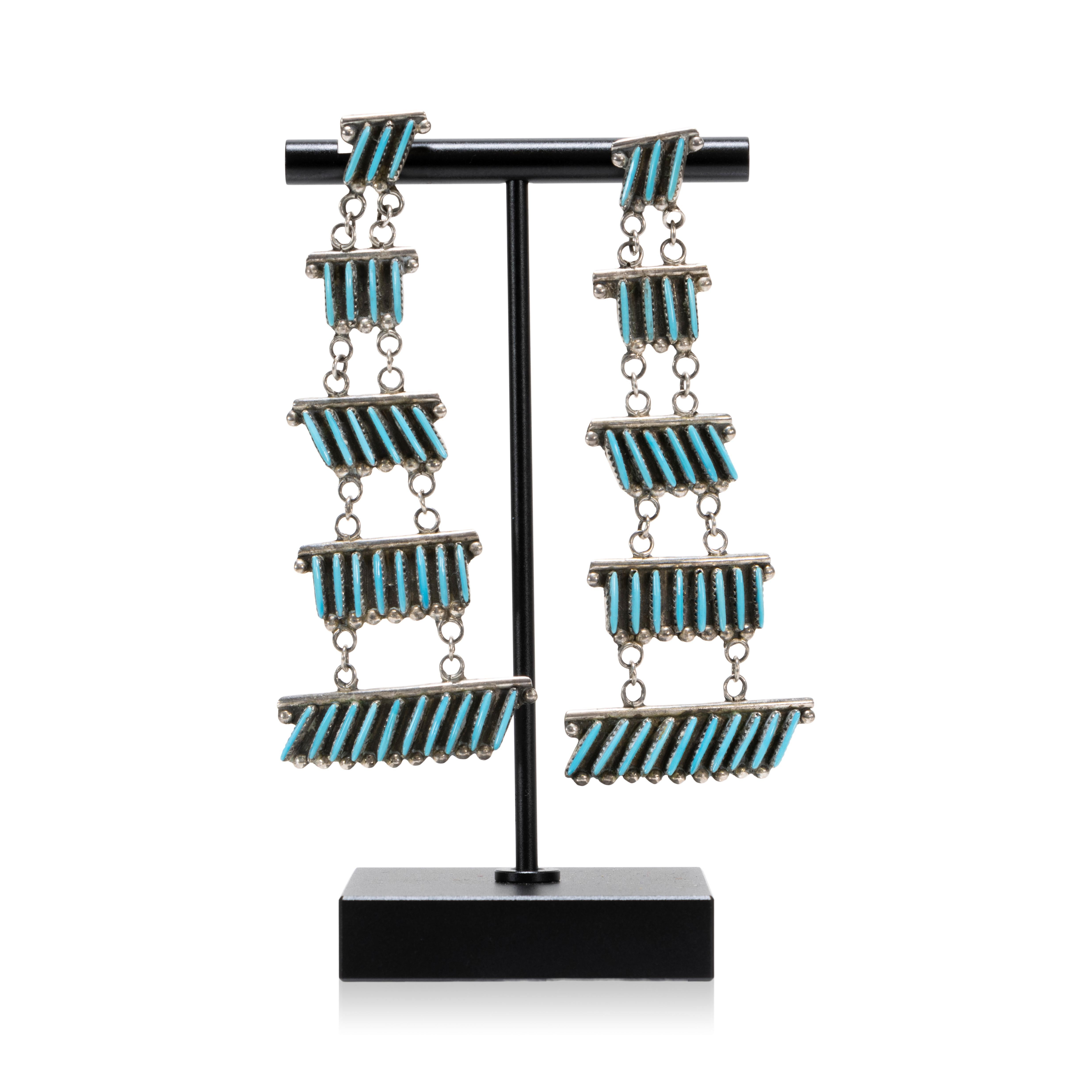 Zuni Sleeping Beauty turquoise needlepoint earrings with 31 slivers of turquoise arranged on four levels. Set in sterling silver. Lightweight with post backs.

PERIOD: Mid 20th Century

ORIGIN: Southwest - Zuni, Native American

SIZE: 3
