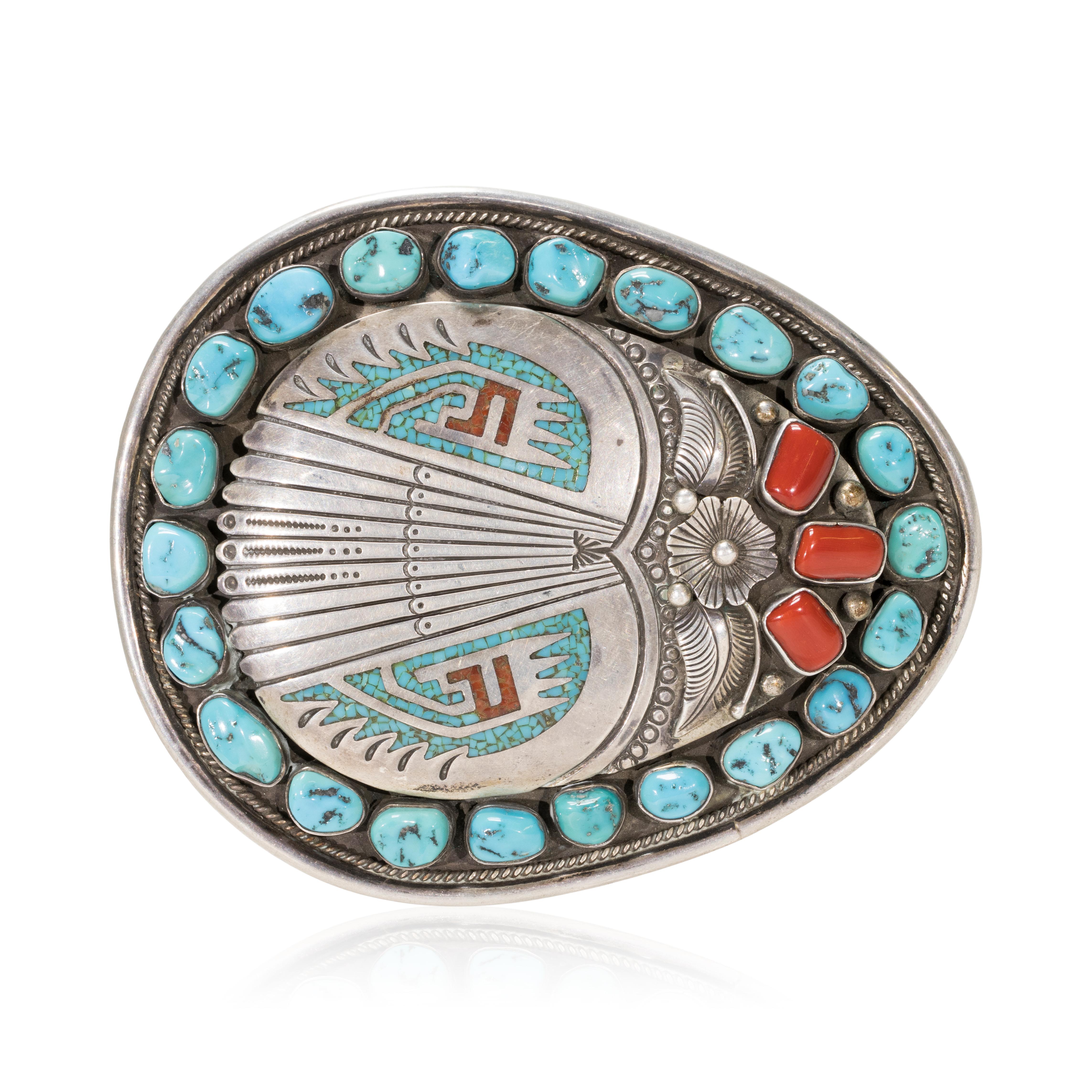 Zuni Sleeping Beauty turquoise and dark red coral buckle. Nuggets surrounded by twisted rop border with stylized thunderbird with wings and tail feathers. Maker's mark 