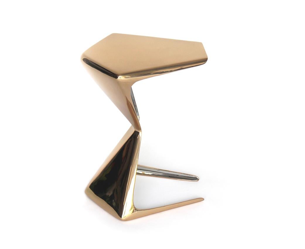 The ZYA table evolved from a platonic solid geometric base form through surface manipulation and proprietary design techniques. This beautiful piece is hammer formed 6 mm thick polished bronze on the exterior and polished stainless steel on the