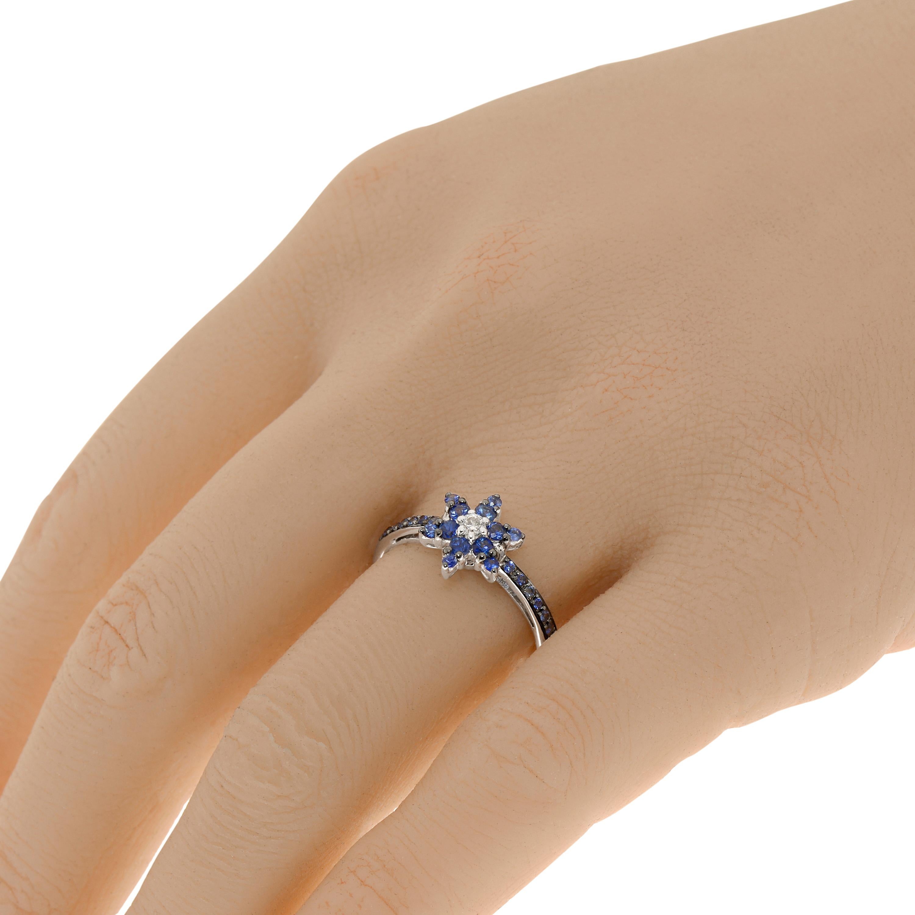 La bague ZYDO en or blanc 18 carats présente une fleur composée de saphirs bleus de 0,42 carat. tw. et de diamants de 0,05 carat. tw. La taille de la bague est de 7 (54.4). La taille de la décoration est de 3/8