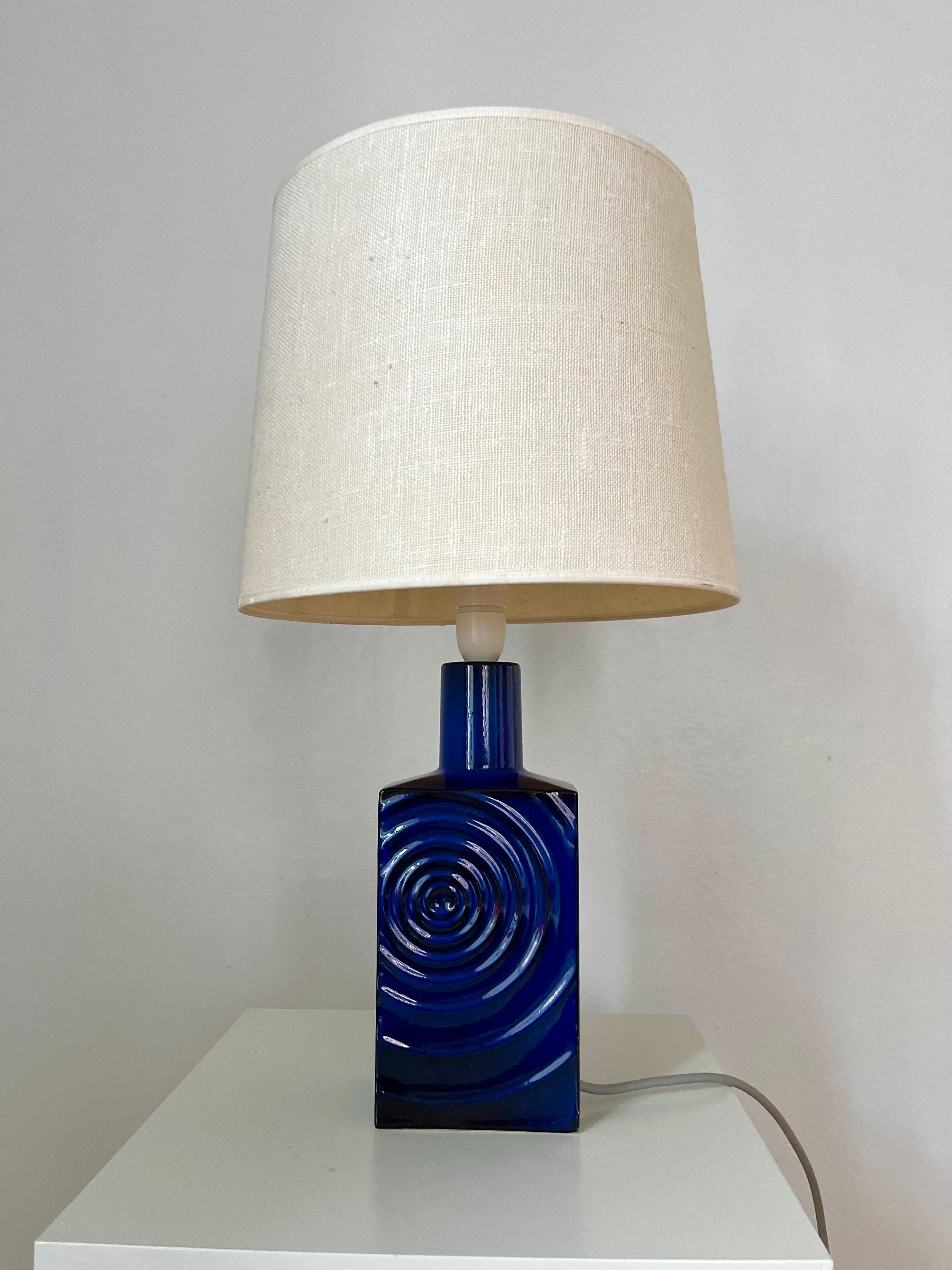 This mid-century modern table lamp 'Zyklon' was designed by Cari Zalloni for German manufacturer Steuler in the 1960s. 
The ceramic table lamp has a deep blue glazing fading into black, a raised circular pattern on the front and backside. 
The